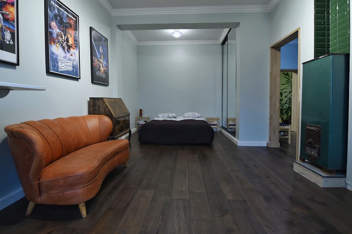 Bedroom with queen bed, mirrored wardrobe, and leather sofa